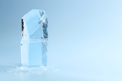 Blocks of clear ice on light blue background, space for text