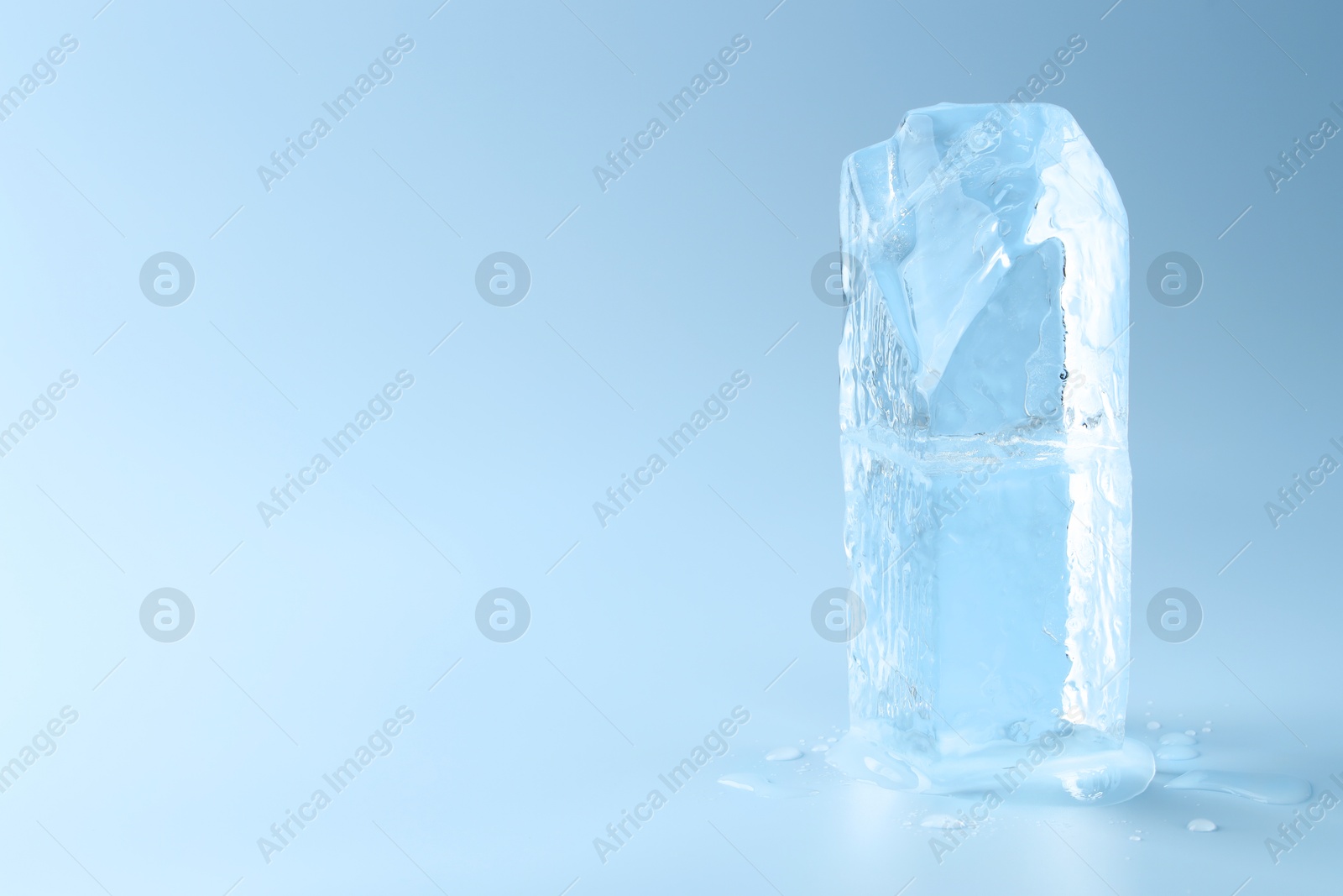 Photo of Blocks of clear ice on light blue background, space for text