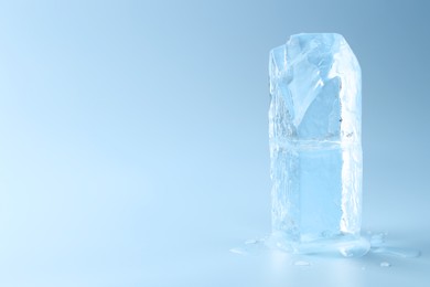 Blocks of clear ice on light blue background, space for text