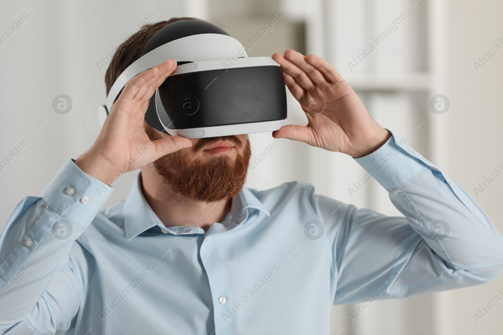 Photo of Man using virtual reality headset in office