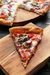 Photo of Wooden board with delicious pizza Diablo on table, closeup