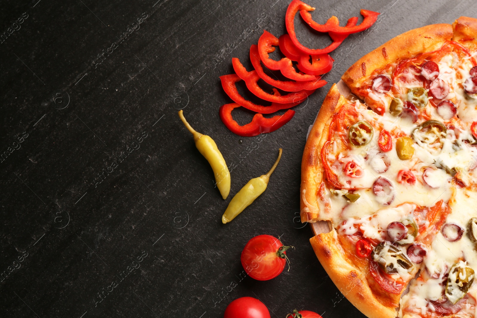 Photo of Delicious pizza Diablo, tomatoes and peppers on dark textured table, flat lay. Space for text