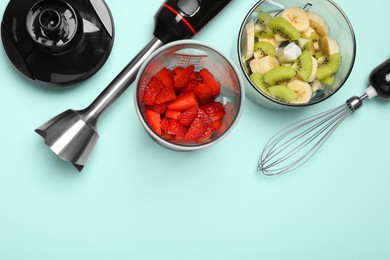 Hand blender kit, fresh fruits and strawberries on turquoise background, flat lay. Space for text