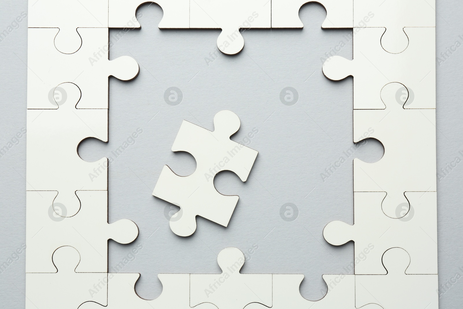 Photo of White puzzle pieces on grey background, top view