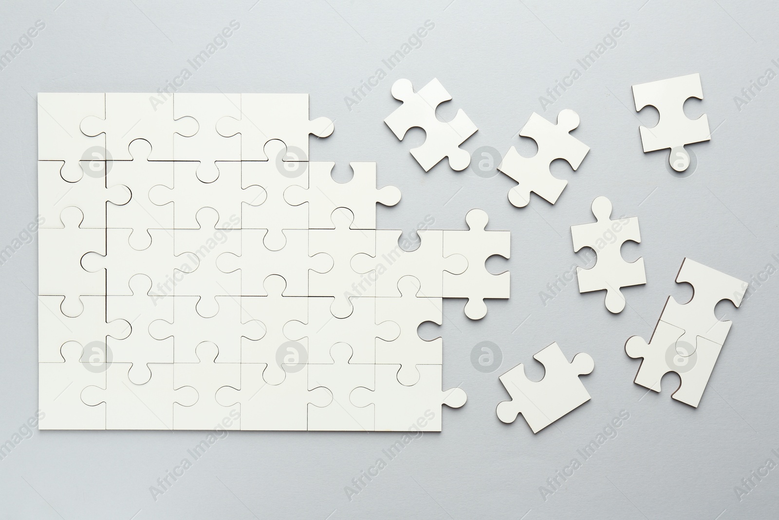 Photo of White puzzle pieces on grey background, top view