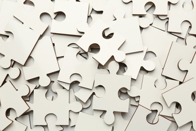 Photo of Pile of white puzzle pieces as background, top view