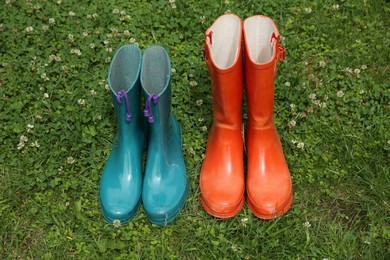 Two pairs of rubber boots on green grass outdoors