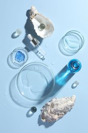 Petri dishes with cosmetic product, pipette and seashells on light blue background, flat lay