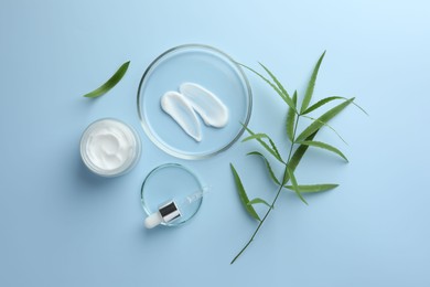 Photo of Petri dishes with cosmetic product, pipette and leaves on light blue background, flat lay