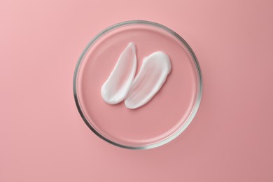 Photo of Petri dish with cosmetic product on pink background, top view