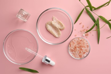 Photo of Petri dishes with cosmetic products, sea salt and leaves on pink background, flat lay