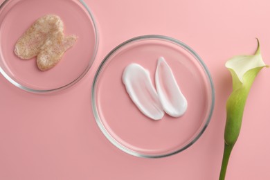 Photo of Petri dishes with cosmetic products and calla lily flower on pink background, flat lay