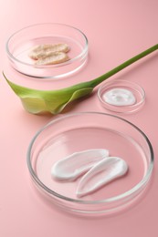 Photo of Petri dishes with cosmetic products and calla lily flower on pink background, closeup