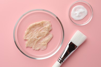 Petri dishes with cosmetic products and brush on pink background, flat lay