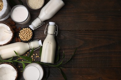 Photo of Different types of vegan milk and ingredients on wooden table, flat lay. Space for text