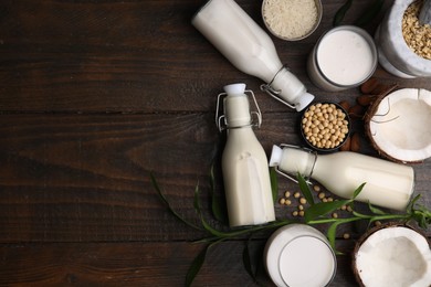 Photo of Different types of vegan milk and ingredients on wooden table, flat lay. Space for text