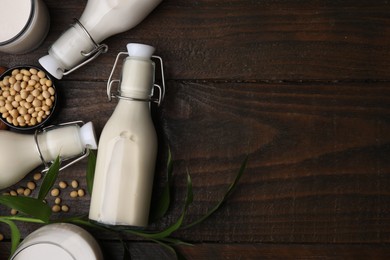 Photo of Different types of vegan milk and ingredients on wooden table, flat lay. Space for text