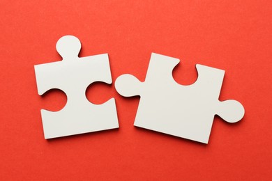 Photo of White puzzle pieces on red background, top view