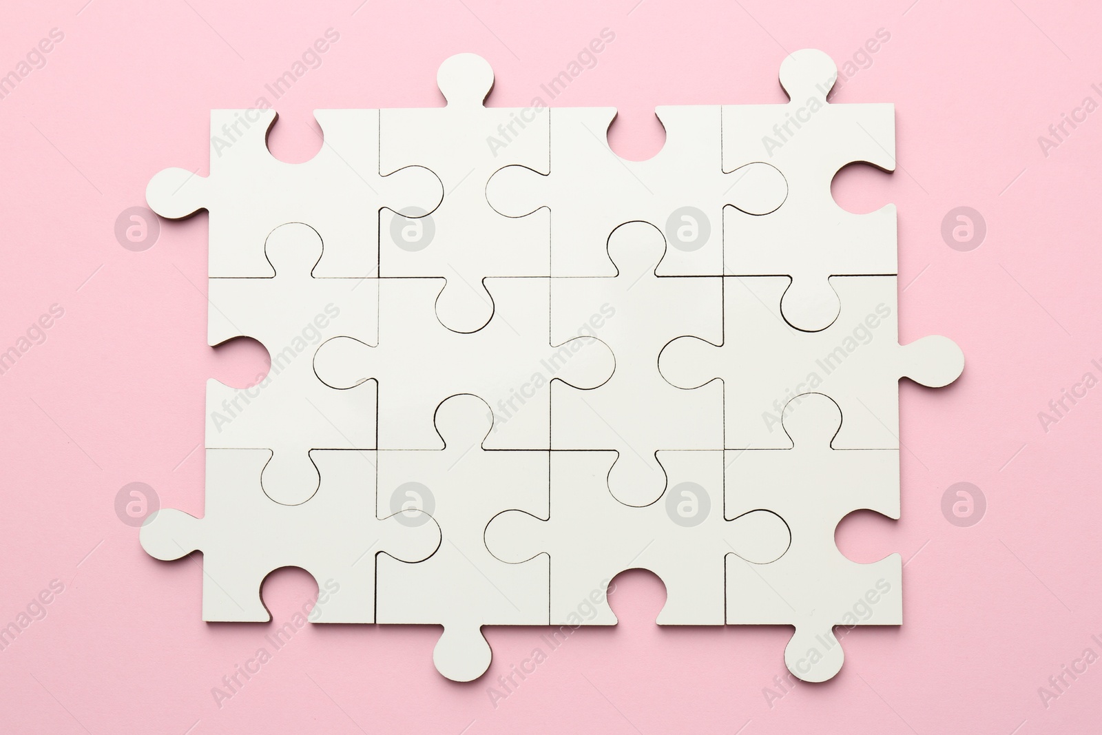 Photo of White puzzle pieces on pink background, top view