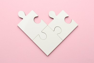 Photo of White puzzle pieces on pink background, top view