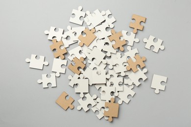 White puzzle pieces on grey background, top view