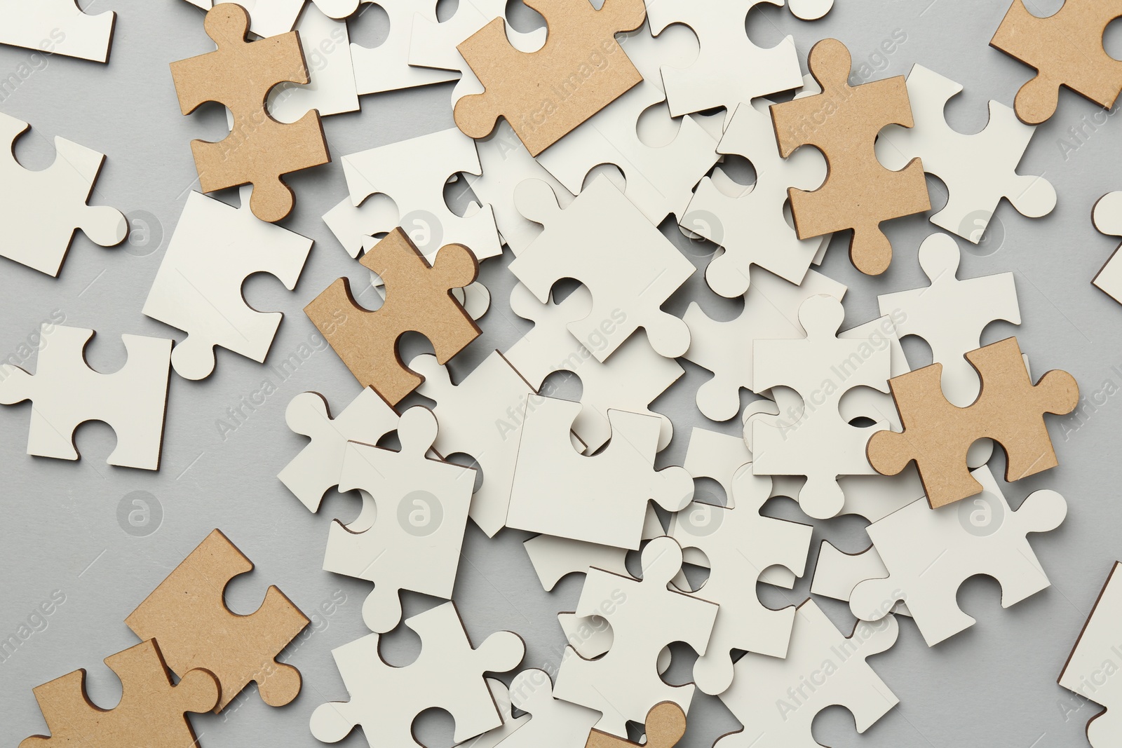 Photo of White puzzle pieces on grey background, top view