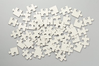 Photo of White puzzle pieces on grey background, top view