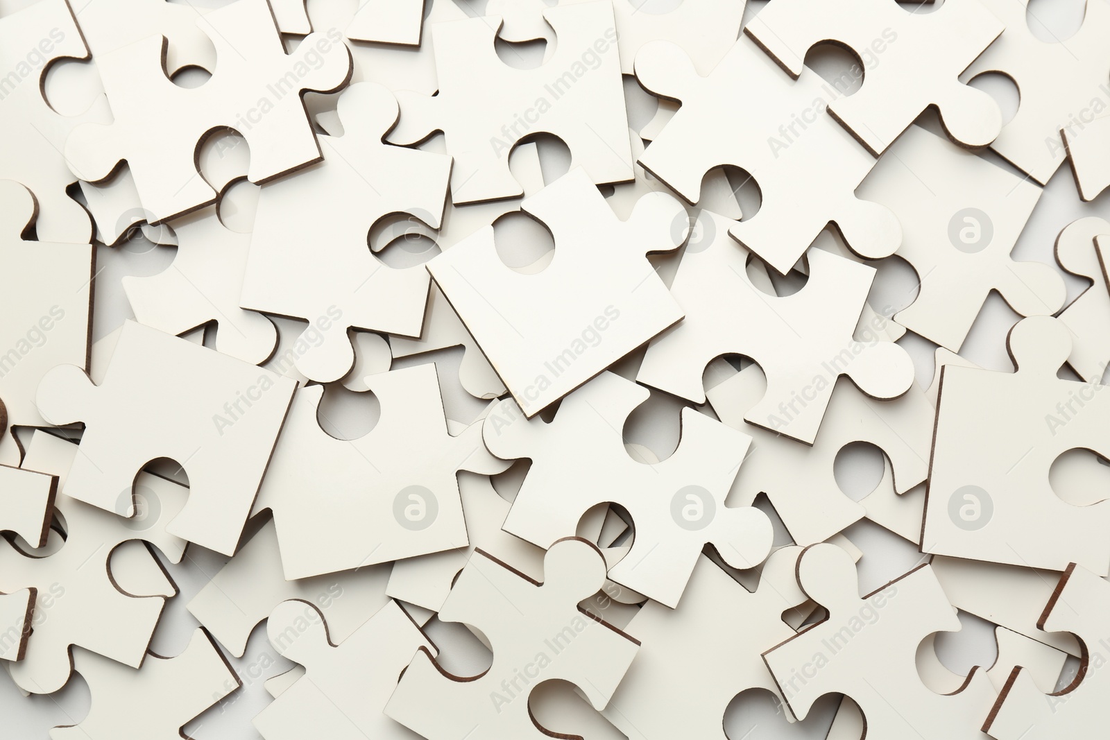 Photo of Pile of white puzzle pieces as background, top view