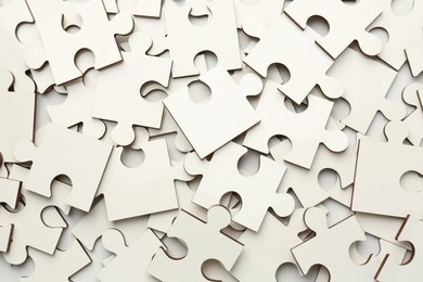 Pile of white puzzle pieces as background, top view