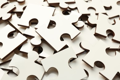 Photo of Pile of white puzzle pieces as background, closeup