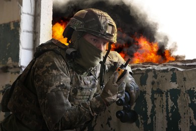 Image of Soldier using radio in destroyed building during military operation