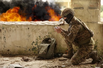 Image of Soldier in uniform with drone controller inside abandoned building during military operation