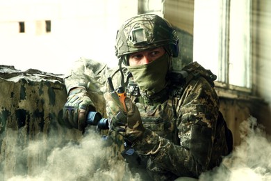 Image of Soldier using radio in building during military operation
