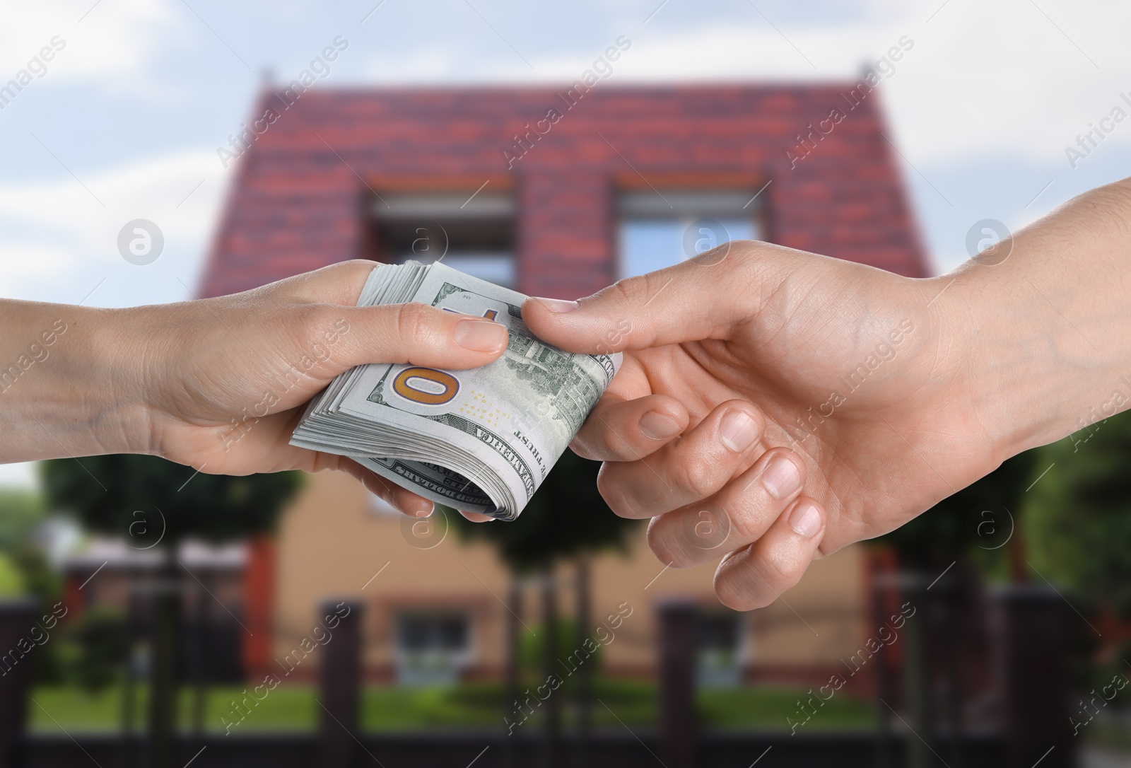 Image of Client giving money to real estate agent against beautiful house, closeup