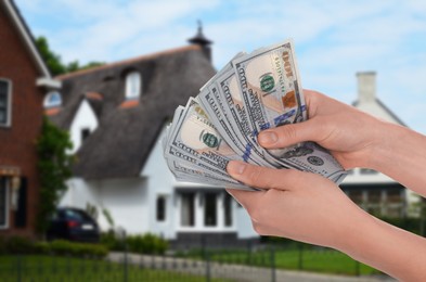 Image of Woman counting money against beautiful house, closeup. Real estate purchase