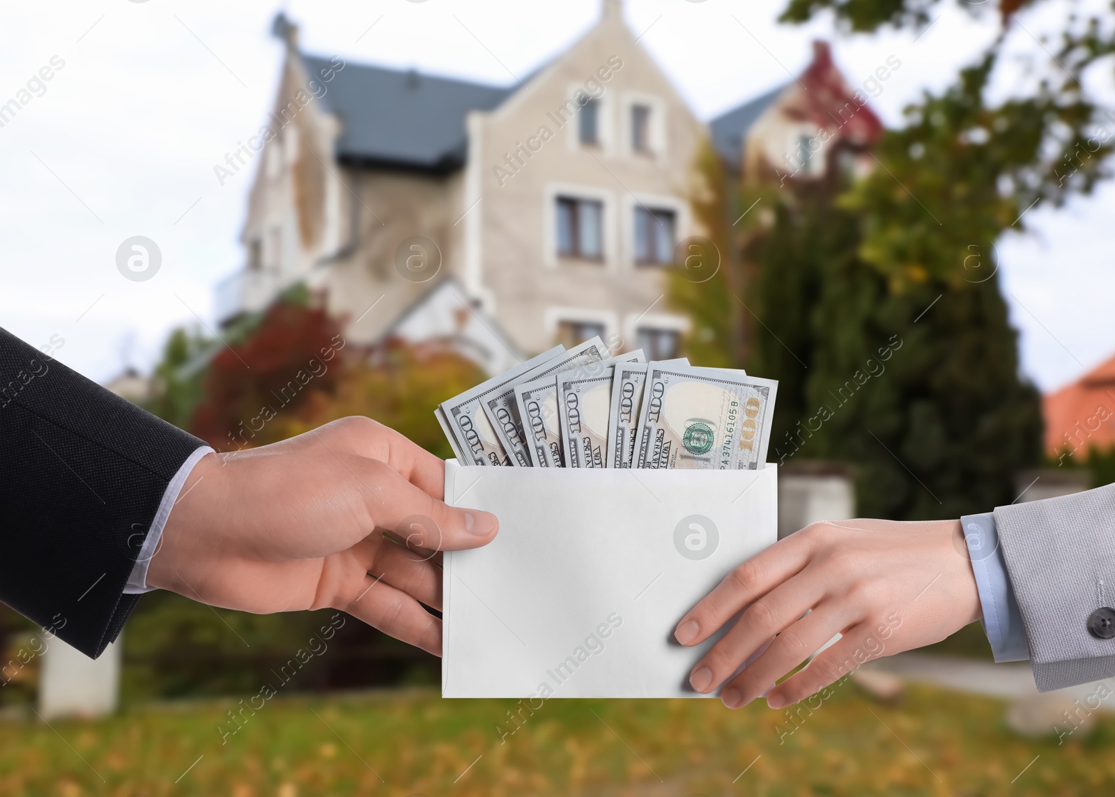 Image of Client giving money to real estate agent against beautiful house, closeup