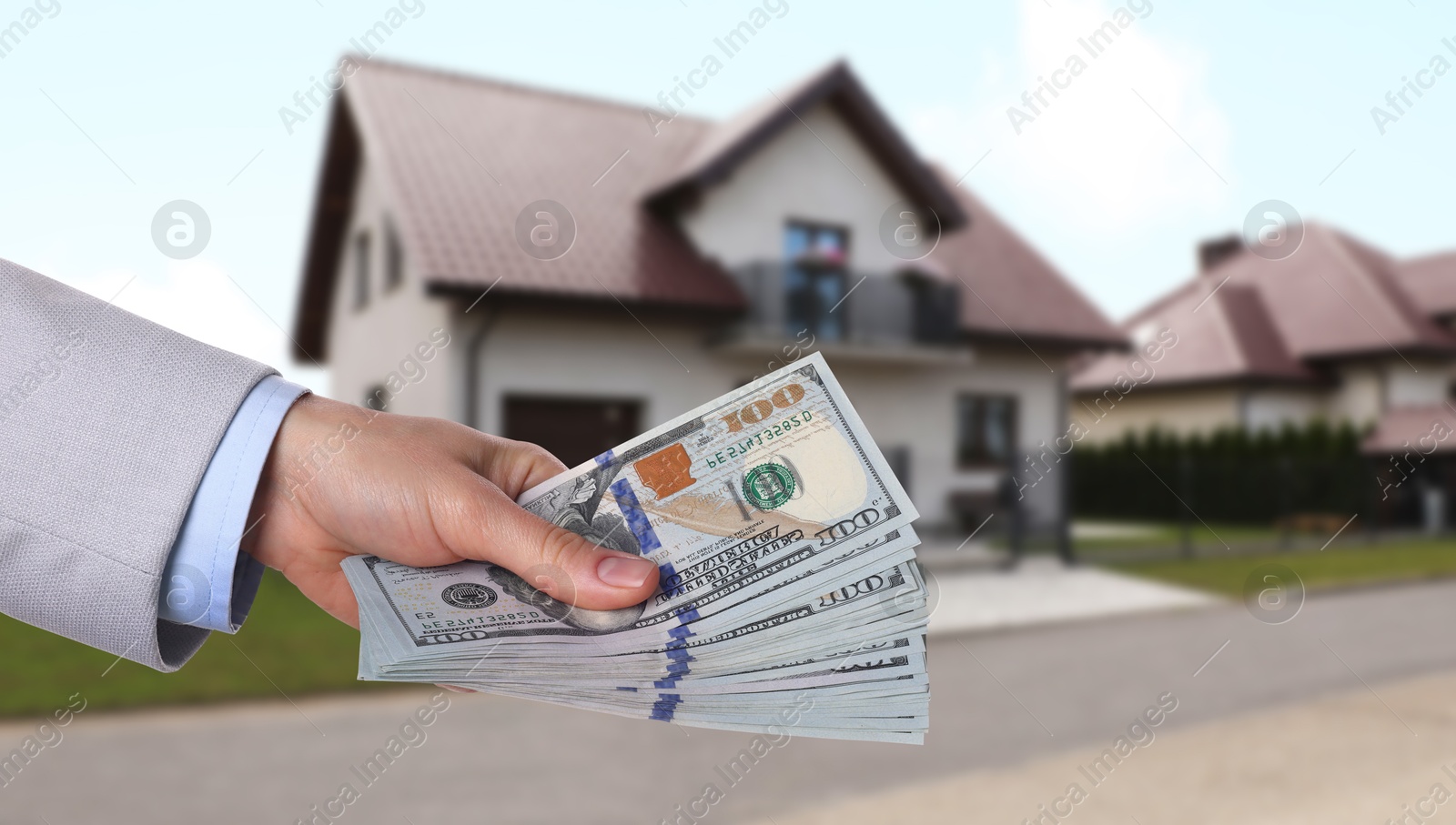 Image of Woman holding money against beautiful house, closeup. Real estate purchase