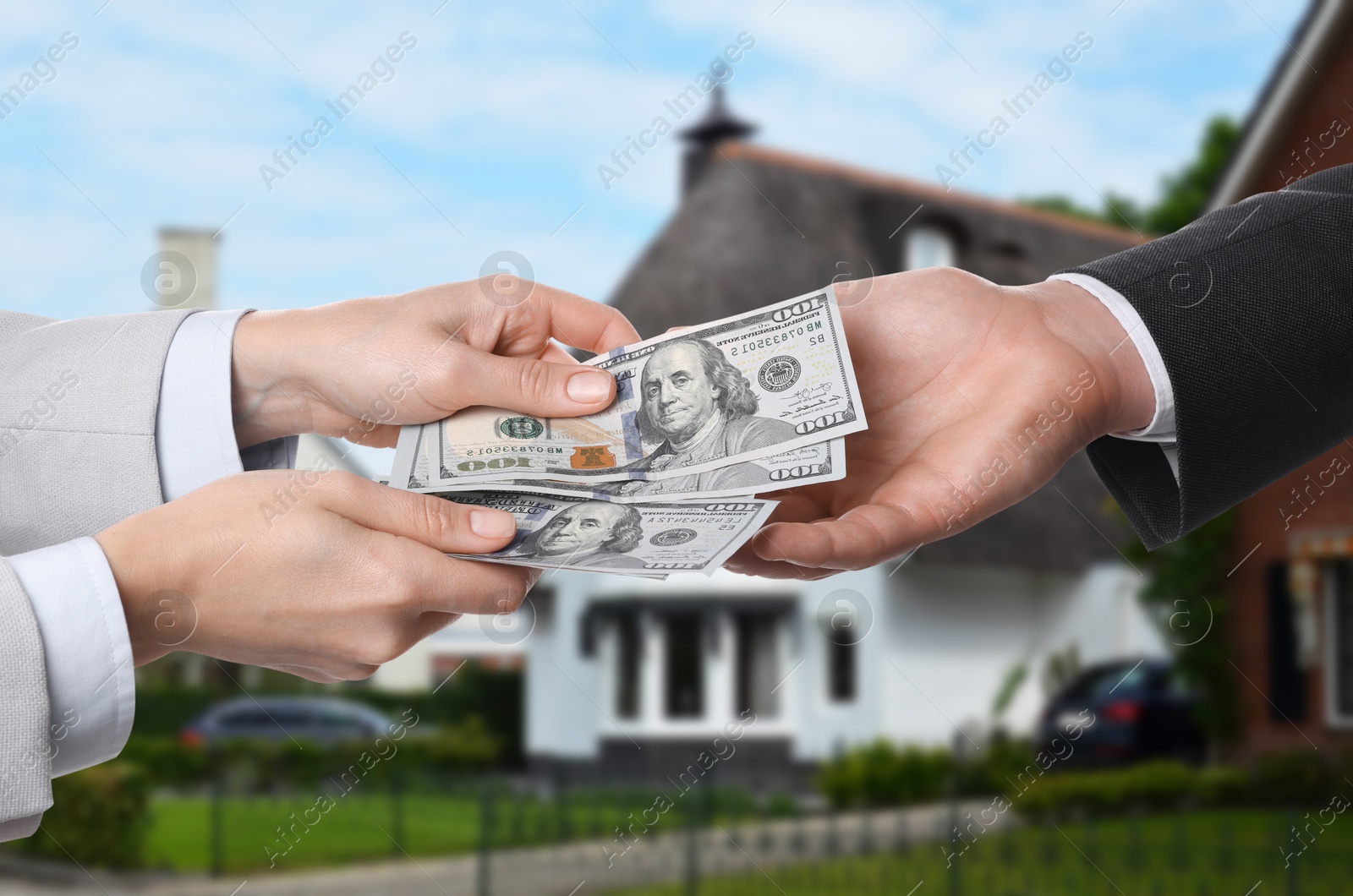 Image of Client giving money to real estate agent against beautiful house, closeup