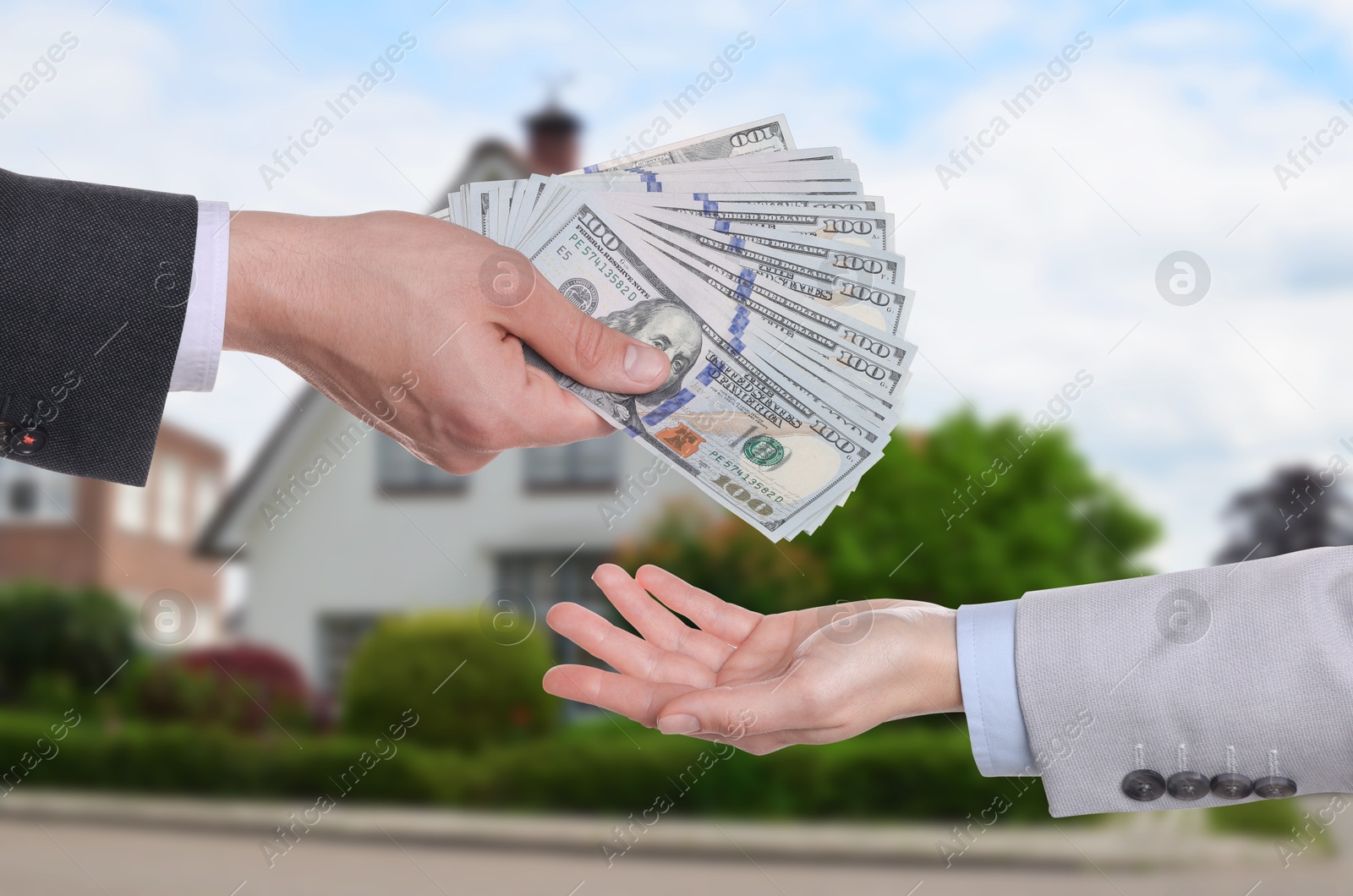 Image of Client giving money to real estate agent against beautiful house, closeup