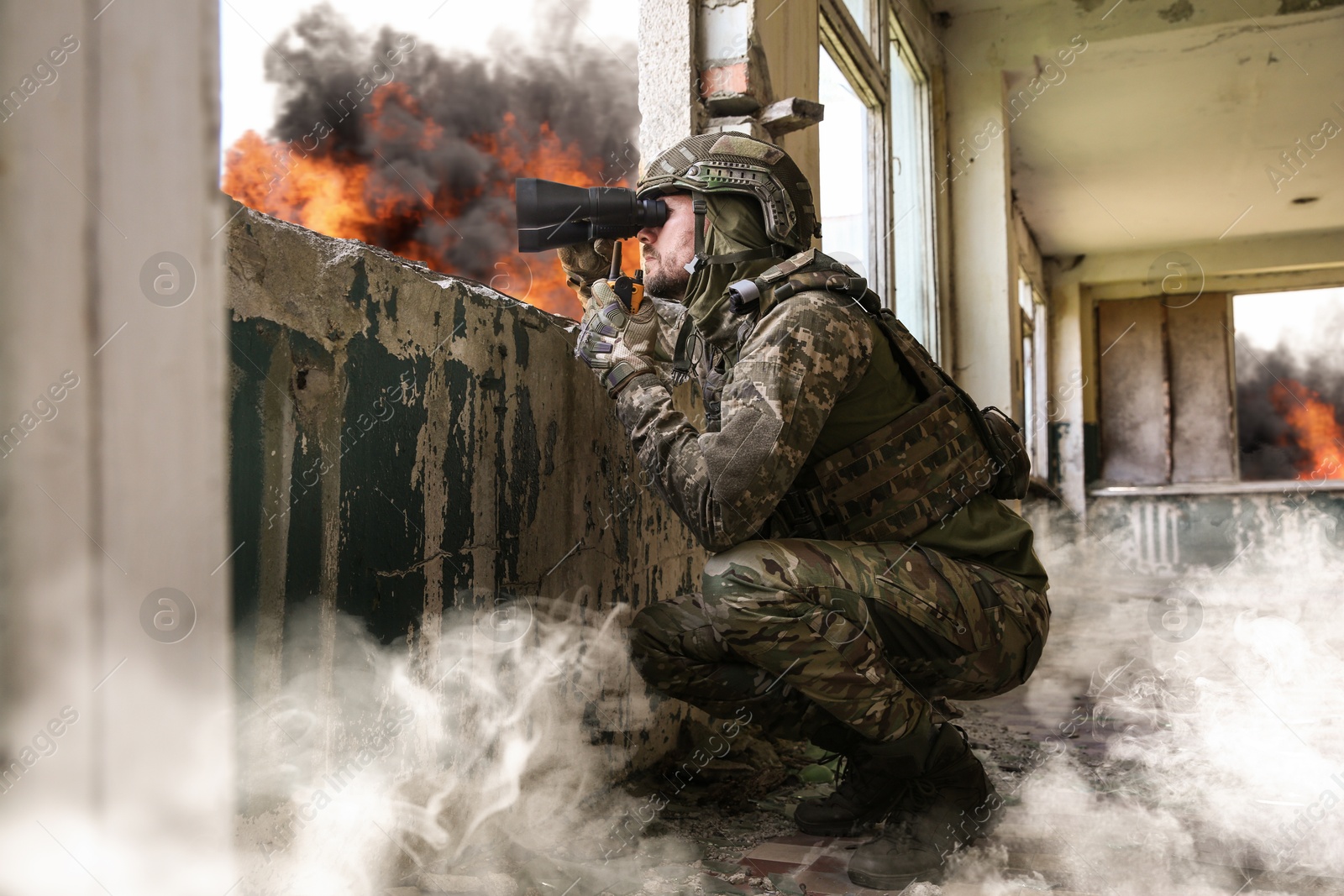 Image of Soldier in uniform with binoculars inside abandoned building during military operation