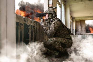Image of Soldier in uniform with binoculars inside abandoned building during military operation