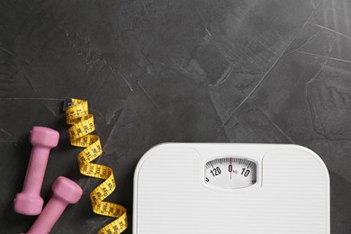 Photo of Bathroom scale, measuring tape and dumbbells on grey textured background, flat lay. Space for text