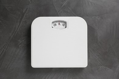 Photo of One bathroom scale on grey textured background, top view