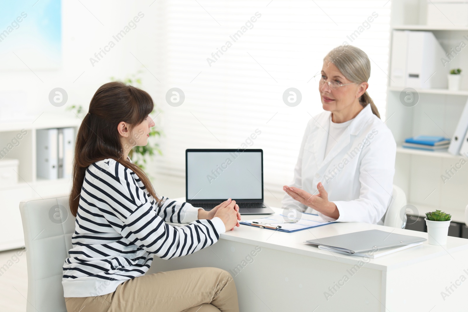 Photo of Lung disease. Doctor showing something on laptop to her patient in clinic