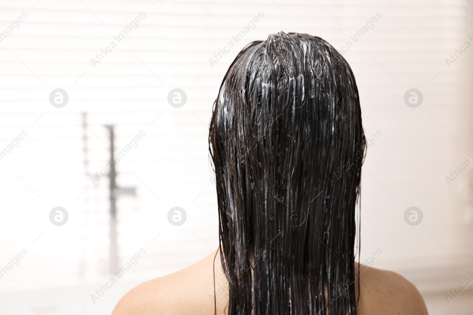 Photo of Woman with applied hair mask in bathroom, back view. Space for text