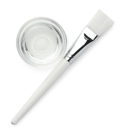 Photo of Bowl of chemical peel and brush isolated on white, top view. Peeling procedure