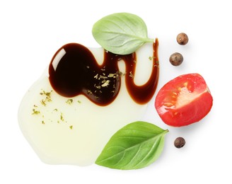 Delicious balsamic vinegar with olive oil, basil, tomato slice and peppercorns on white background, top view