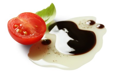 Delicious balsamic vinegar with olive oil, basil and cut tomato on white background