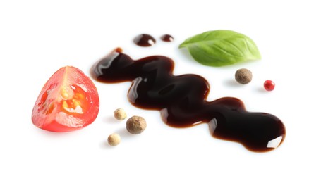 Photo of Delicious balsamic vinegar, cut tomato, basil and peppercorns isolated on white