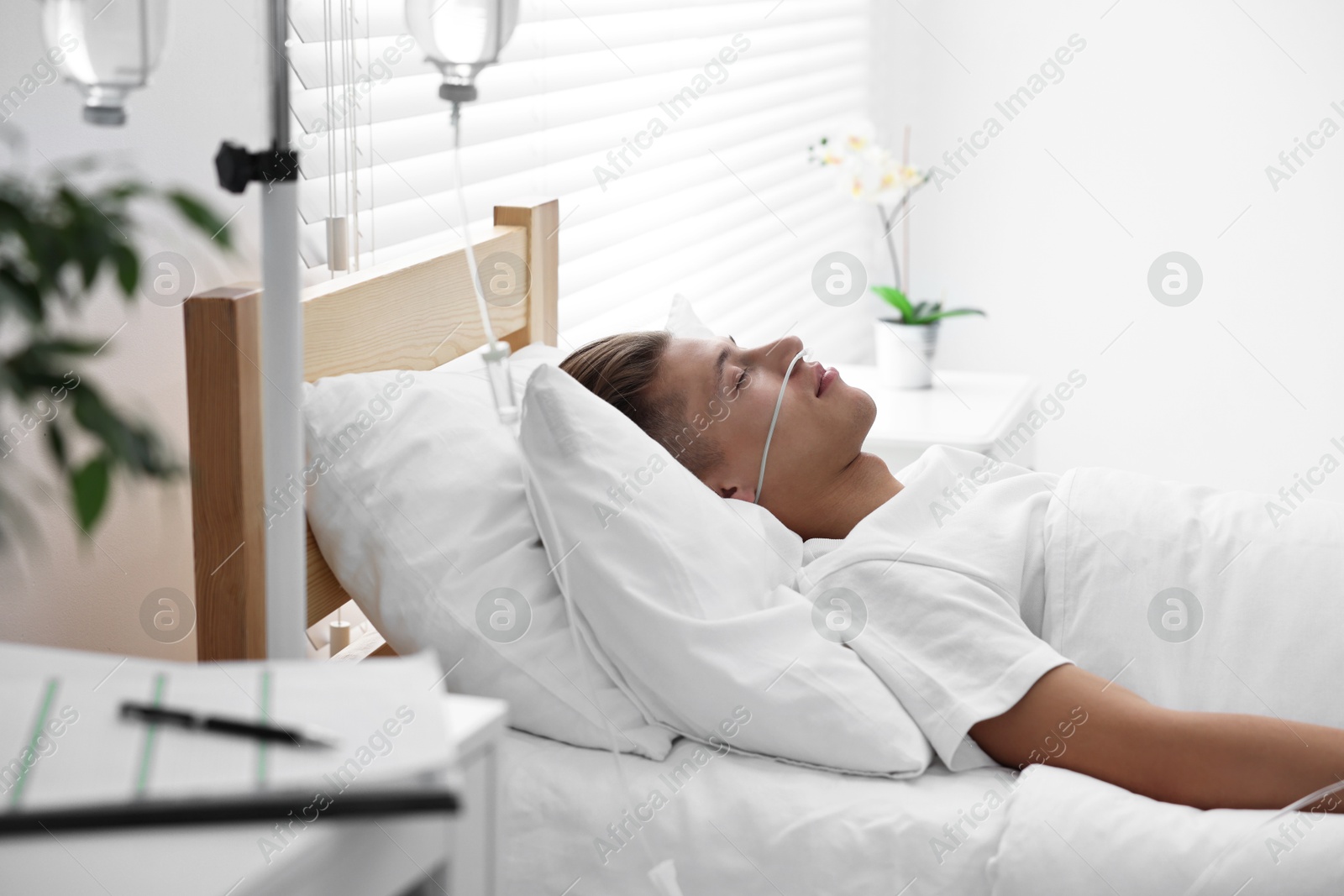 Photo of Coma patient. Young man sleeping in hospital bed